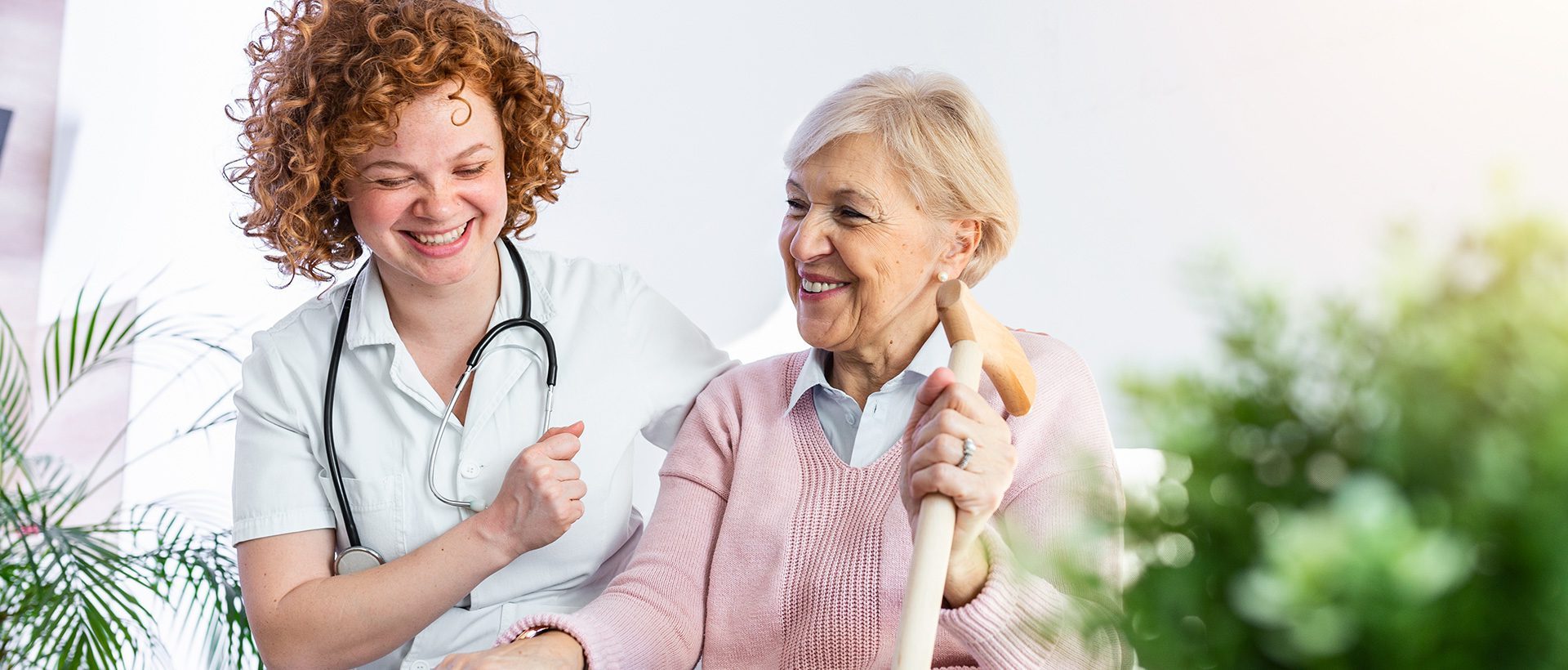 Verpleegkundige van Thuiszorg Forever Care lacht samen met een cliënt in de tuin